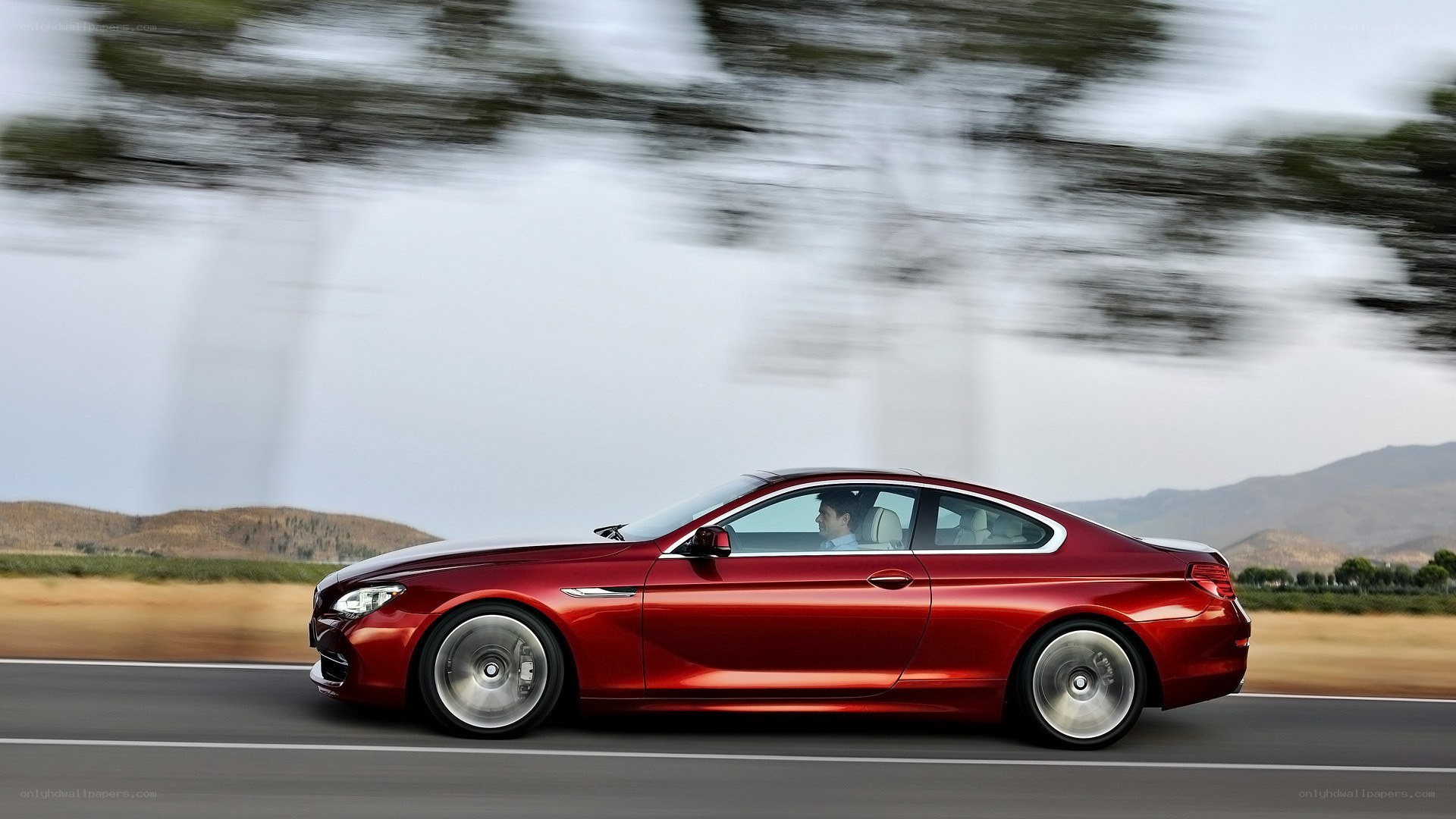Red coupe in motion on road
