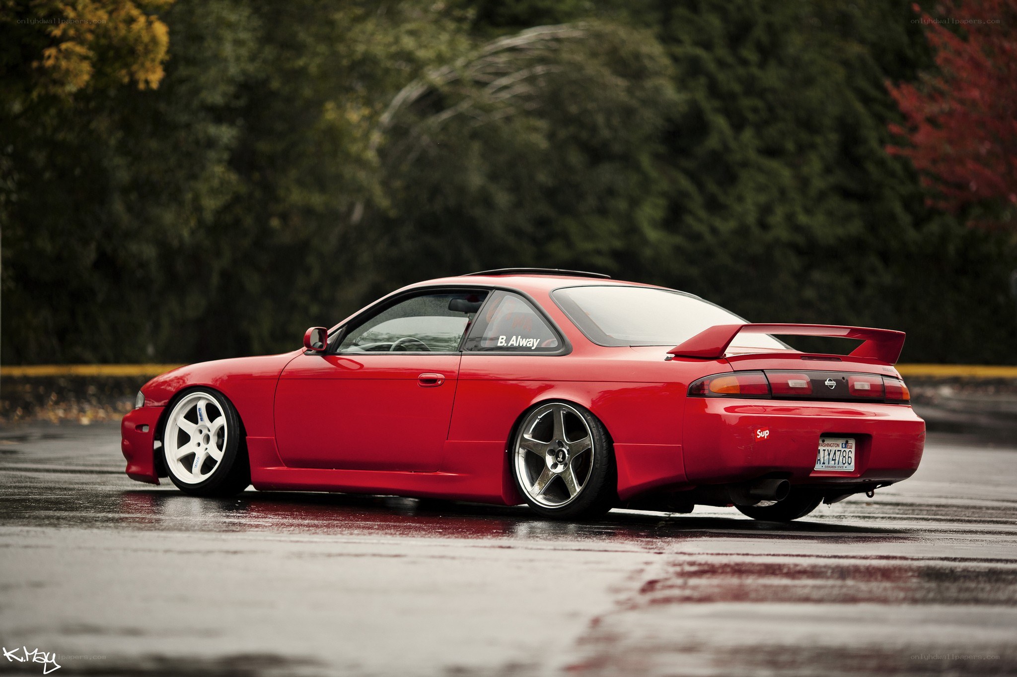 red coupe on wet pavement