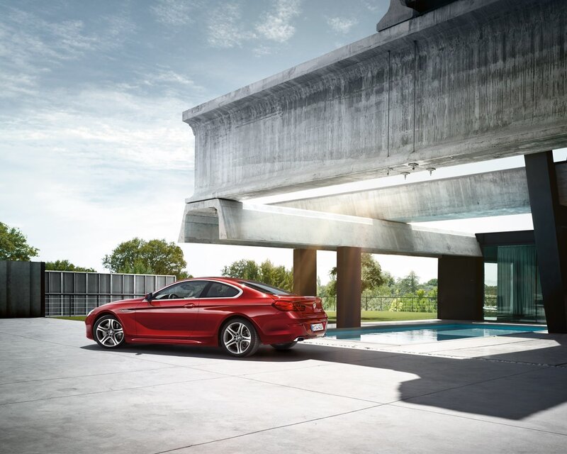 Red coupe under concrete structure