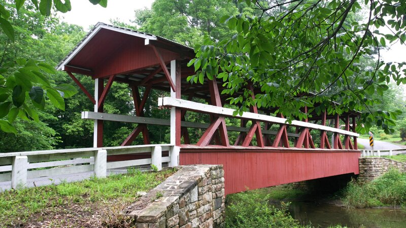Red covered bridge in forest