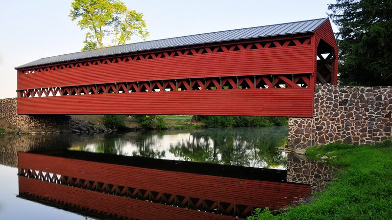 Red covered bridge over river