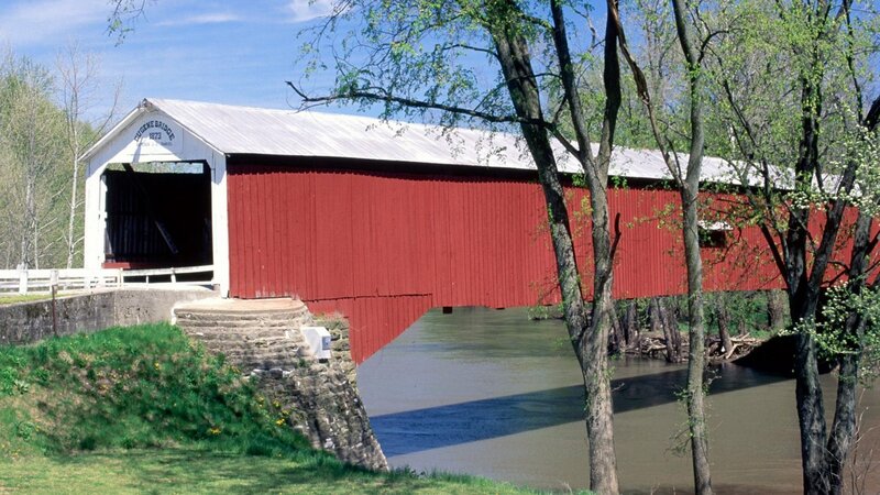 Red covered bridge over river