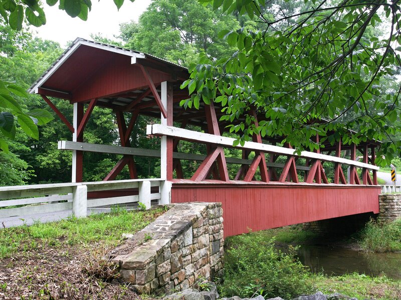 Red covered bridge over stream