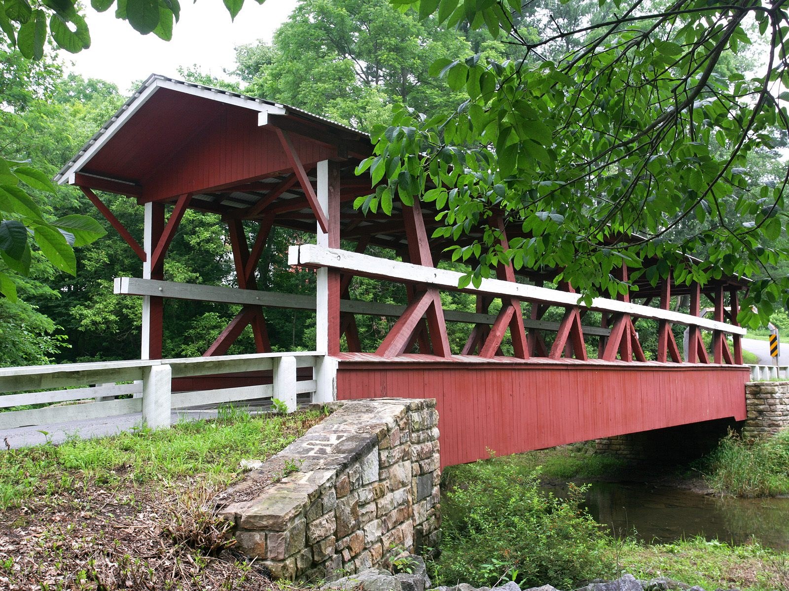 Red covered bridge over stream
