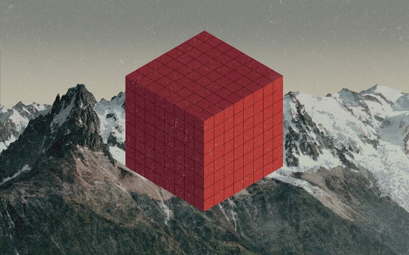 Red cube over snowy mountains