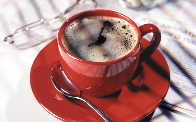 Red cup of coffee on saucer