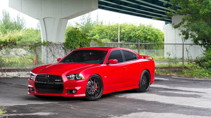 Red Dodge Charger SRT parked under bridge