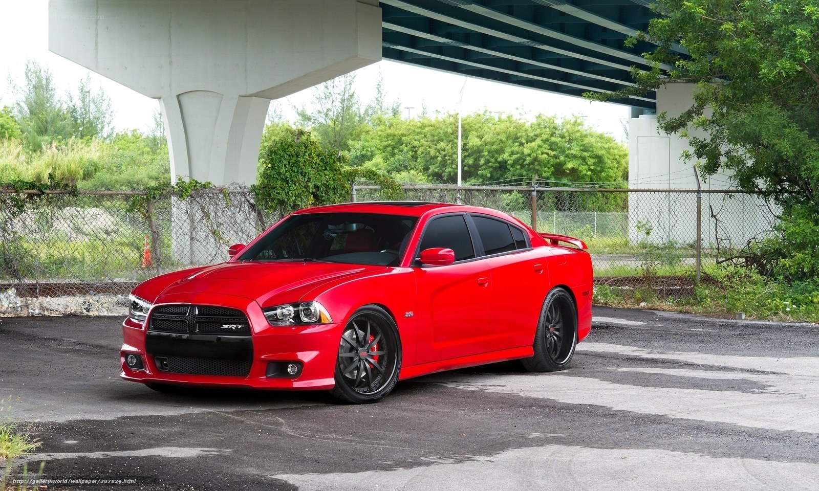 Red Dodge Charger SRT parked under bridge