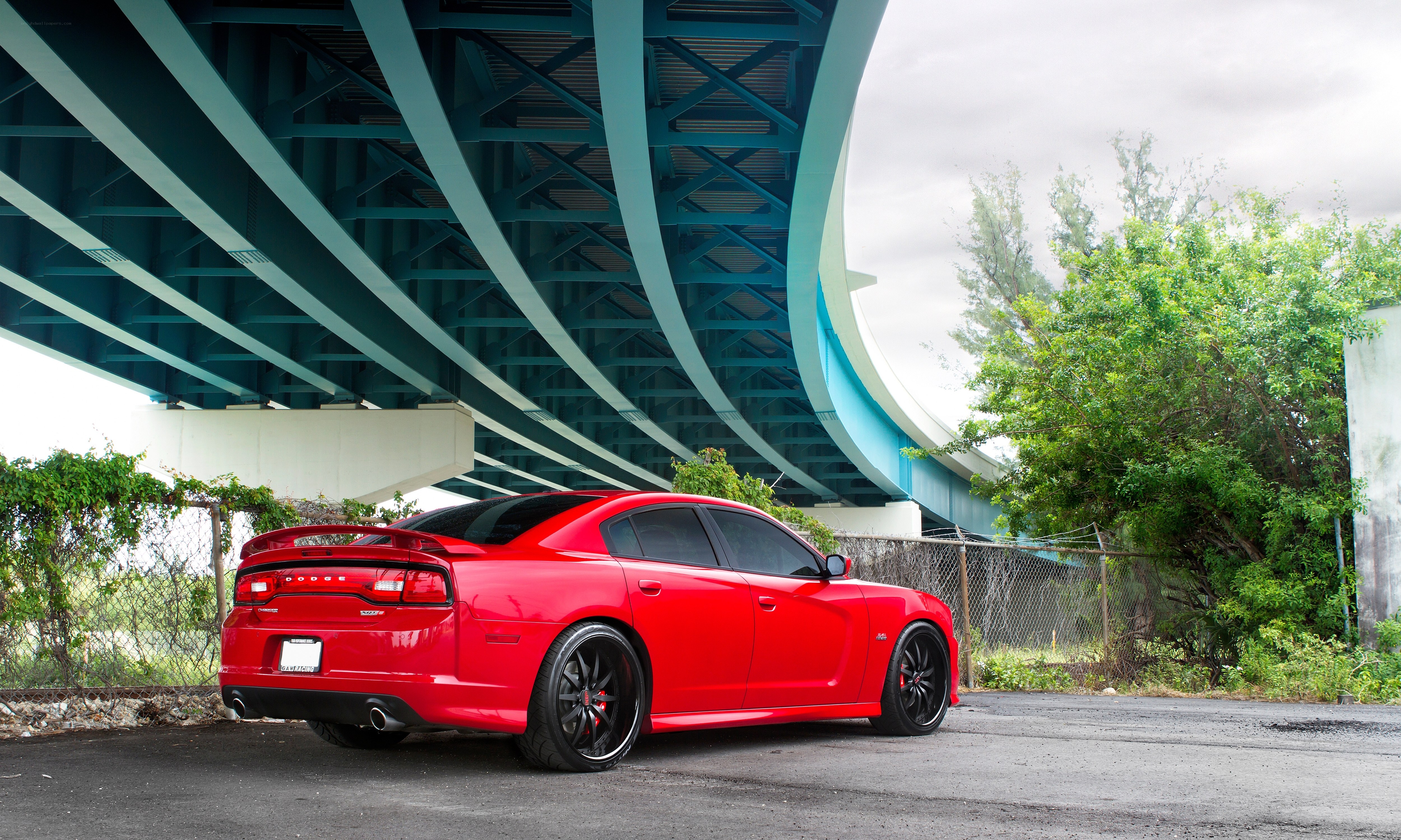 Red Dodge Charger under bridge