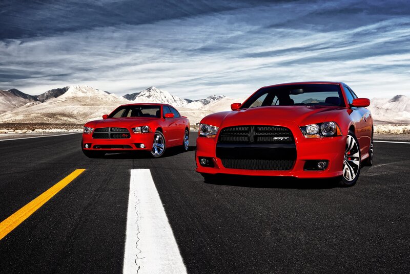 Red Dodge Chargers on a desert road