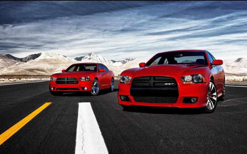 Red Dodge Chargers on a road