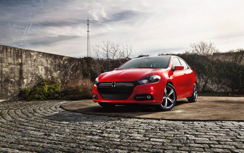 Red Dodge Dart parked on cobblestones