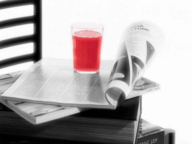 Red drink on newspaper stack