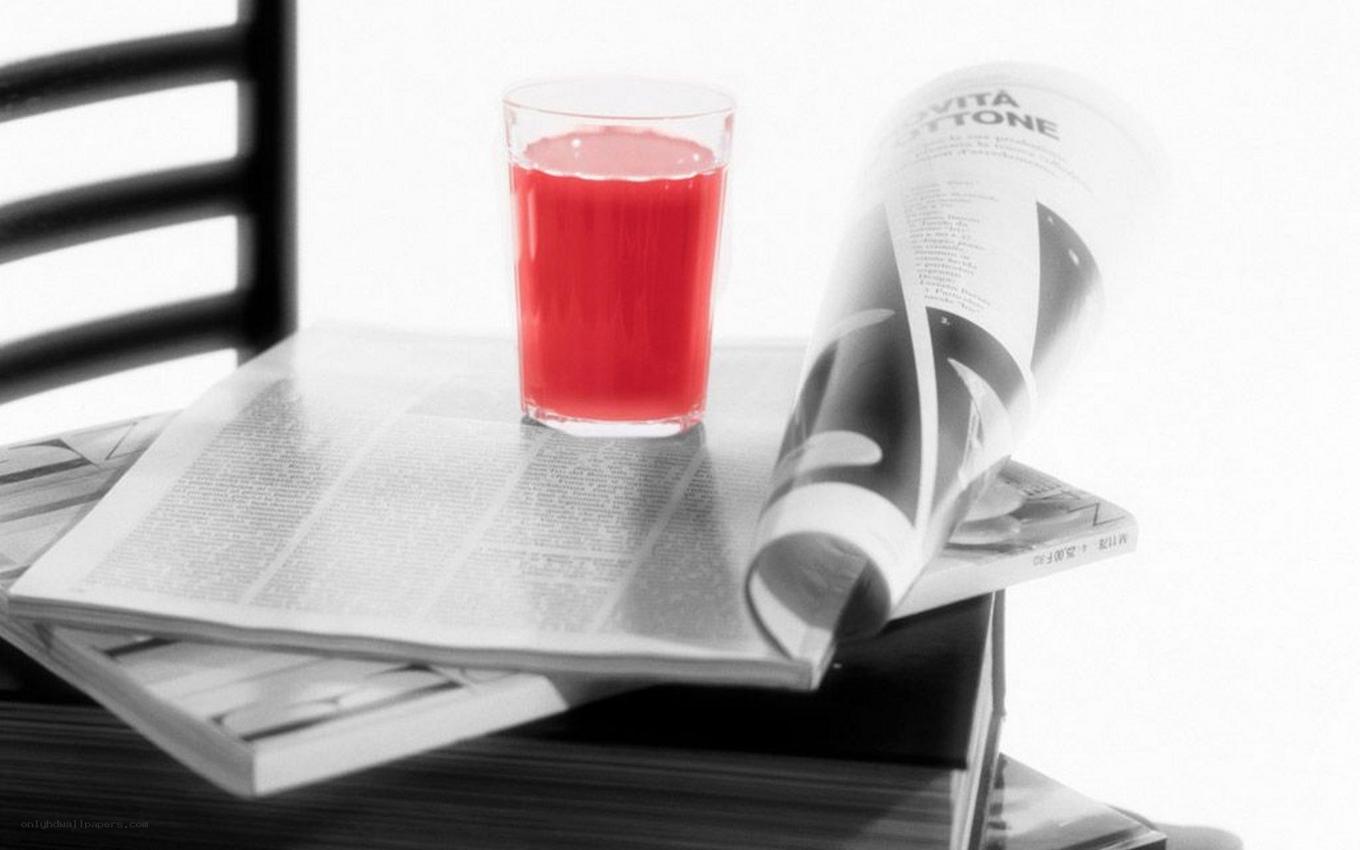 Red drink on newspaper stack