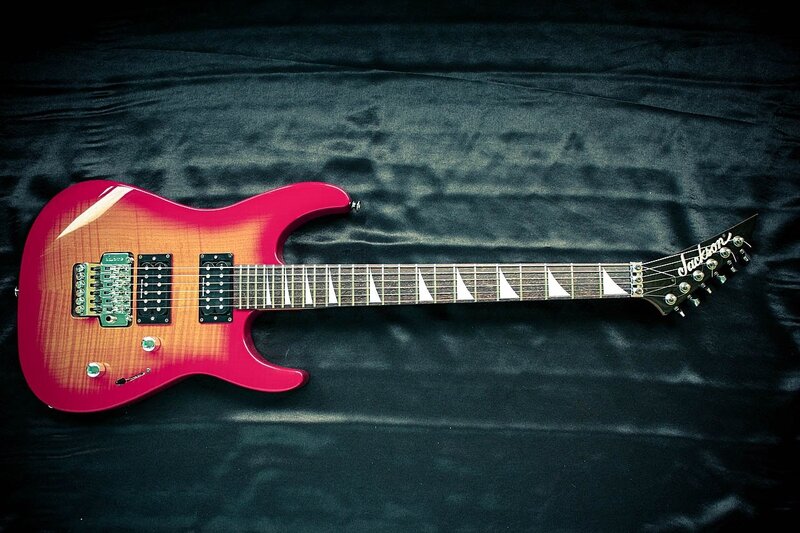 red electric guitar on black cloth