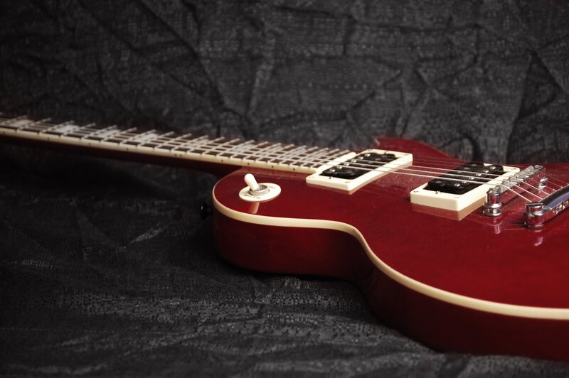 Red electric guitar on black cloth