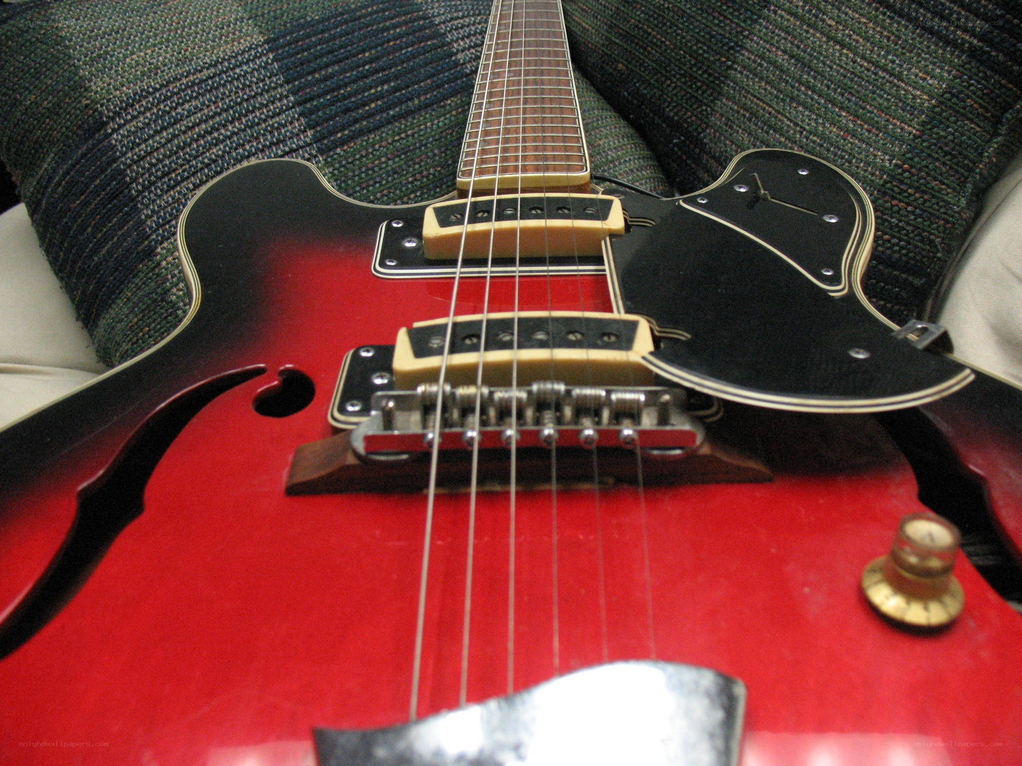 red electric guitar on couch