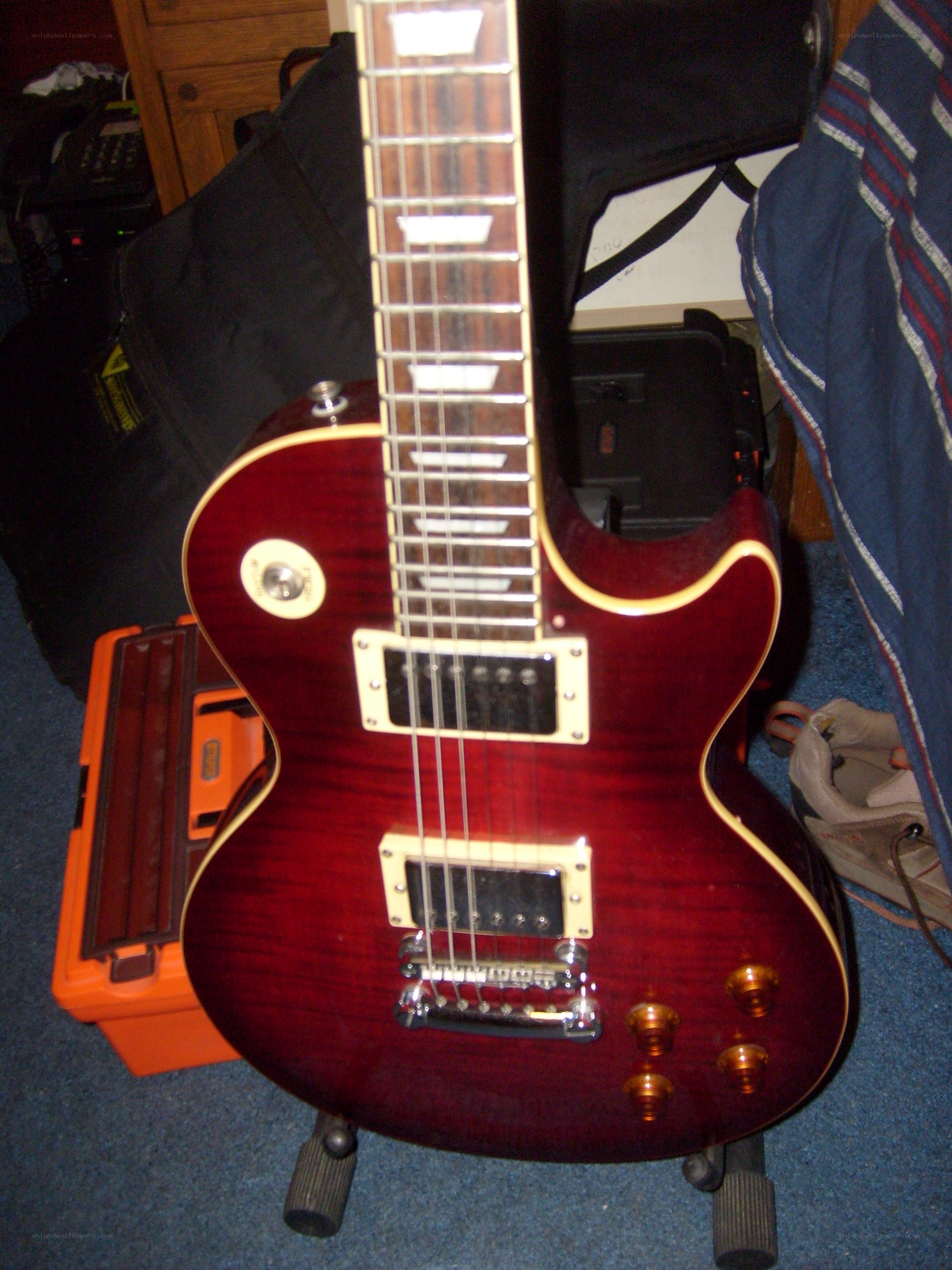 red electric guitar on stand