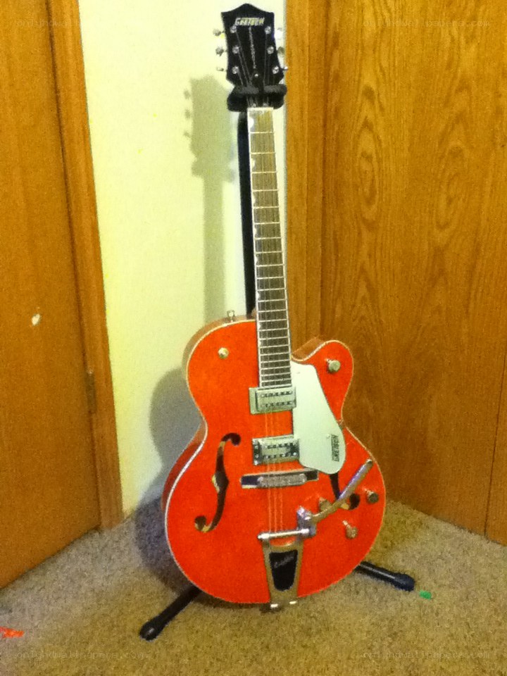 red electric guitar on stand
