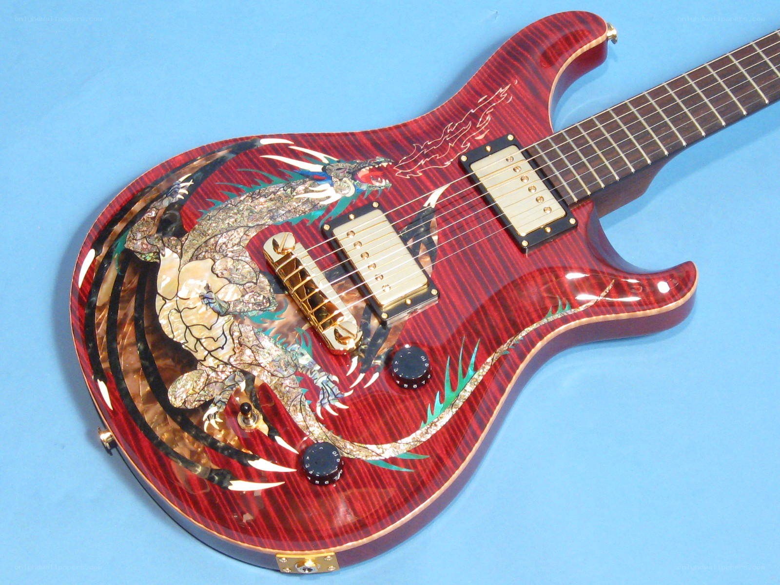 red electric guitar with dragon inlay