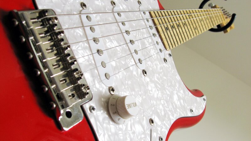 red electric guitar with white pickguard