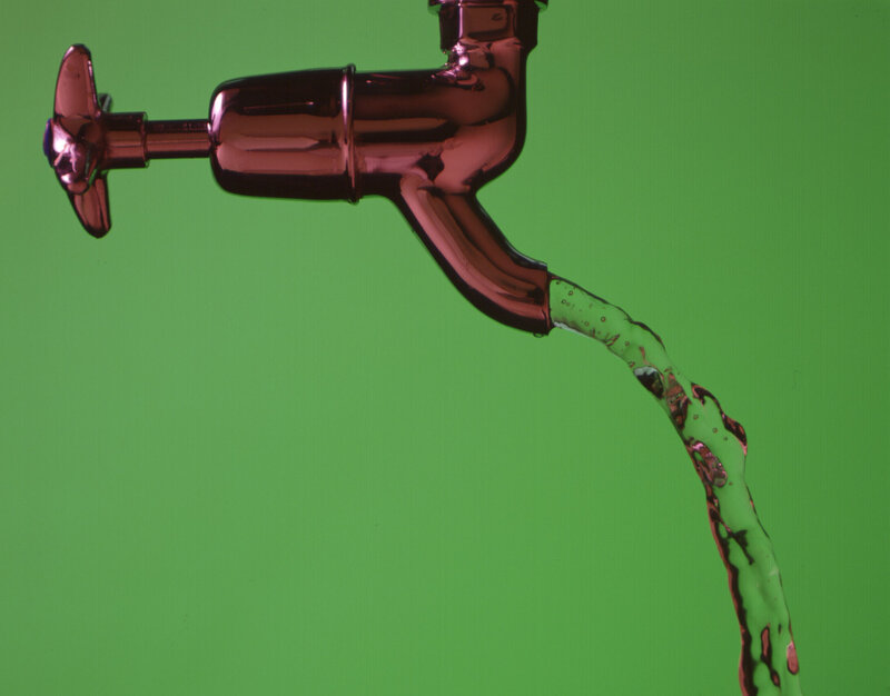 Red faucet with flowing water