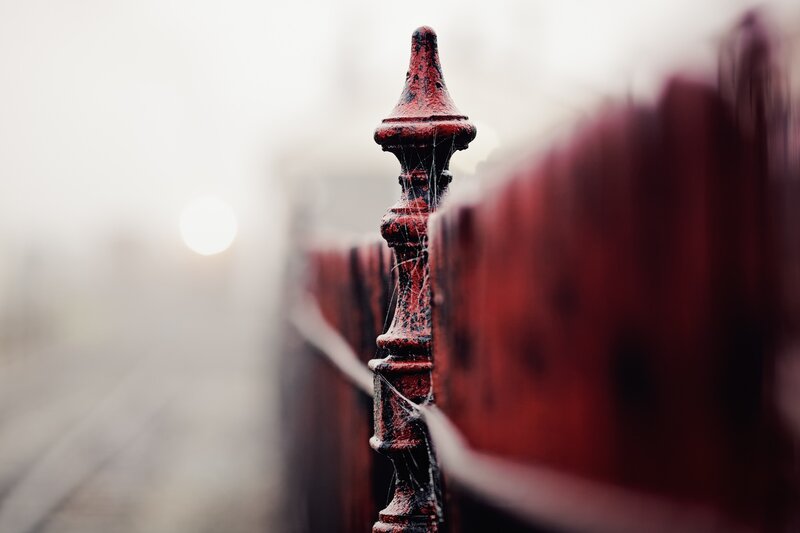 Red fence post in fog