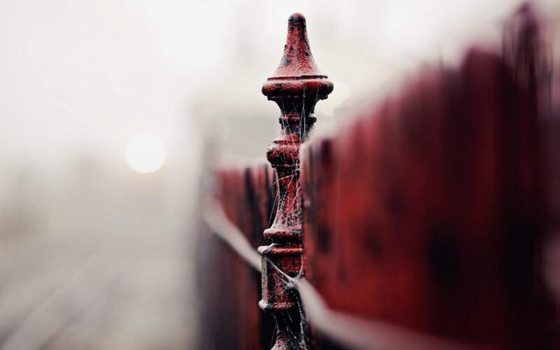 Red fence post in fog