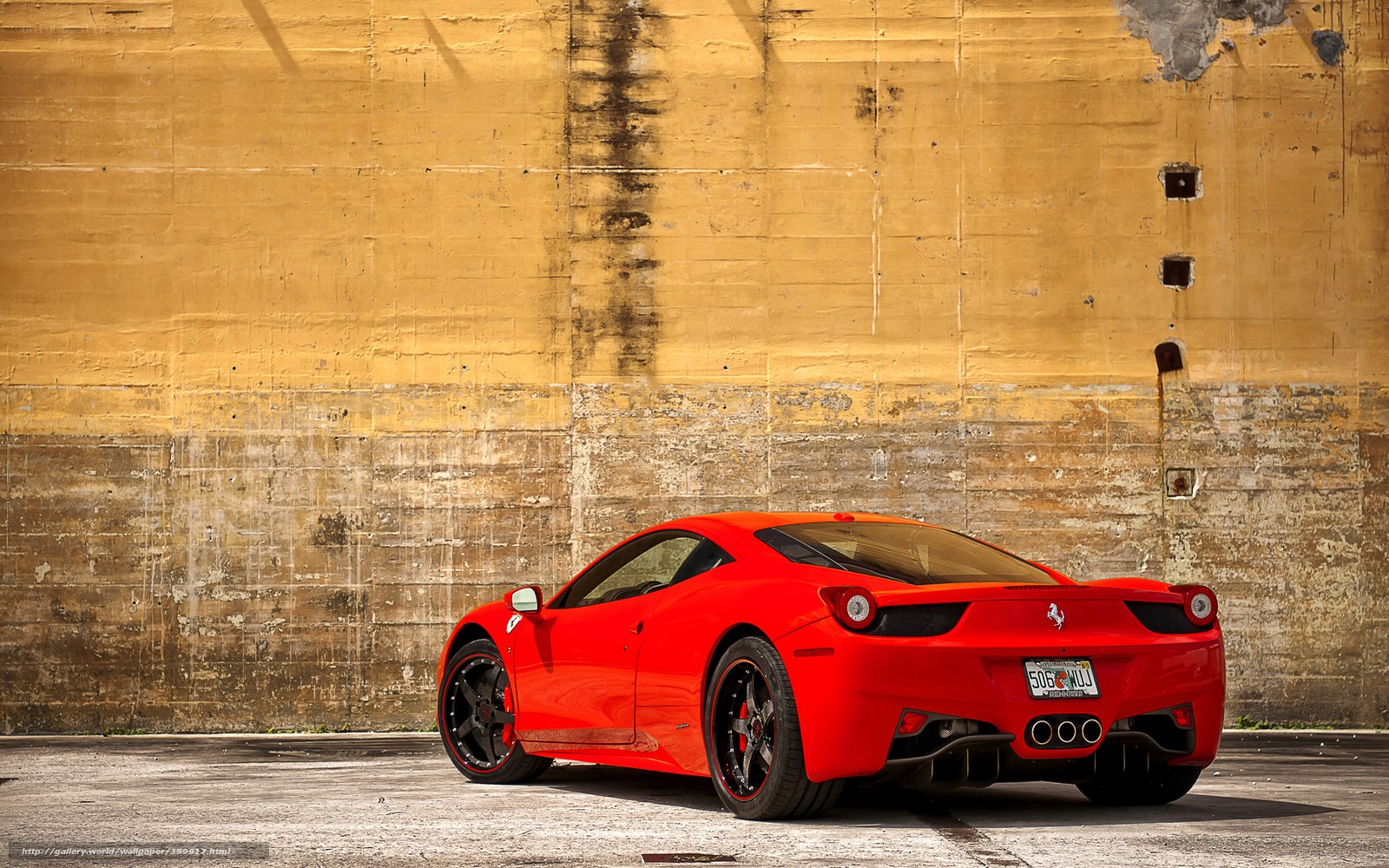 Red Ferrari 458 against concrete wall