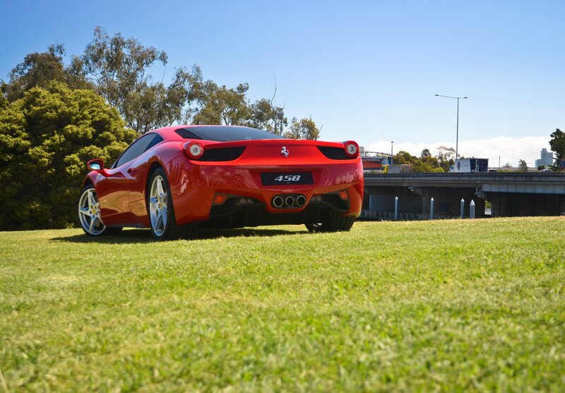 Red Ferrari 458 on a grassy field