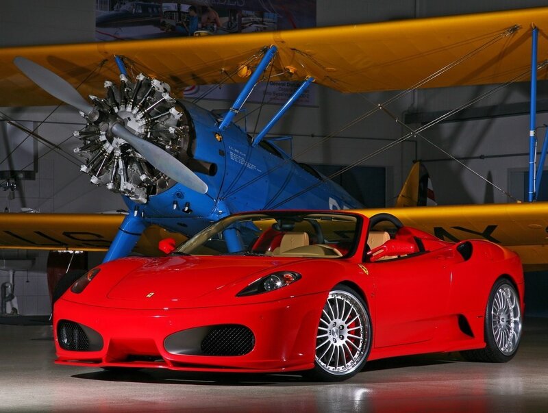 Red Ferrari and vintage airplane