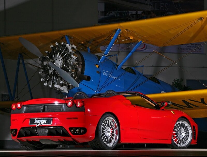 Red Ferrari and vintage airplane
