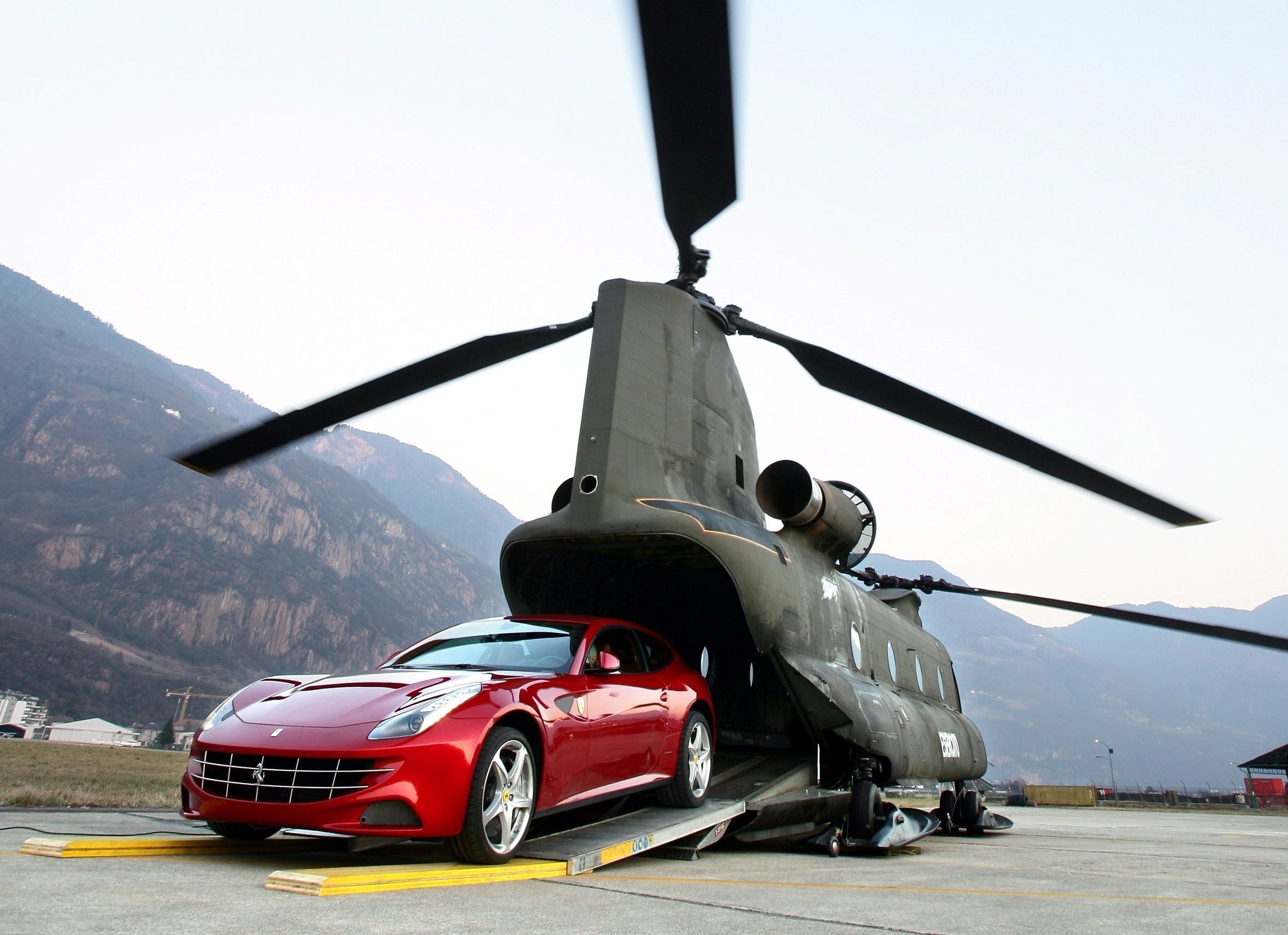 Red Ferrari being loaded into helicopter
