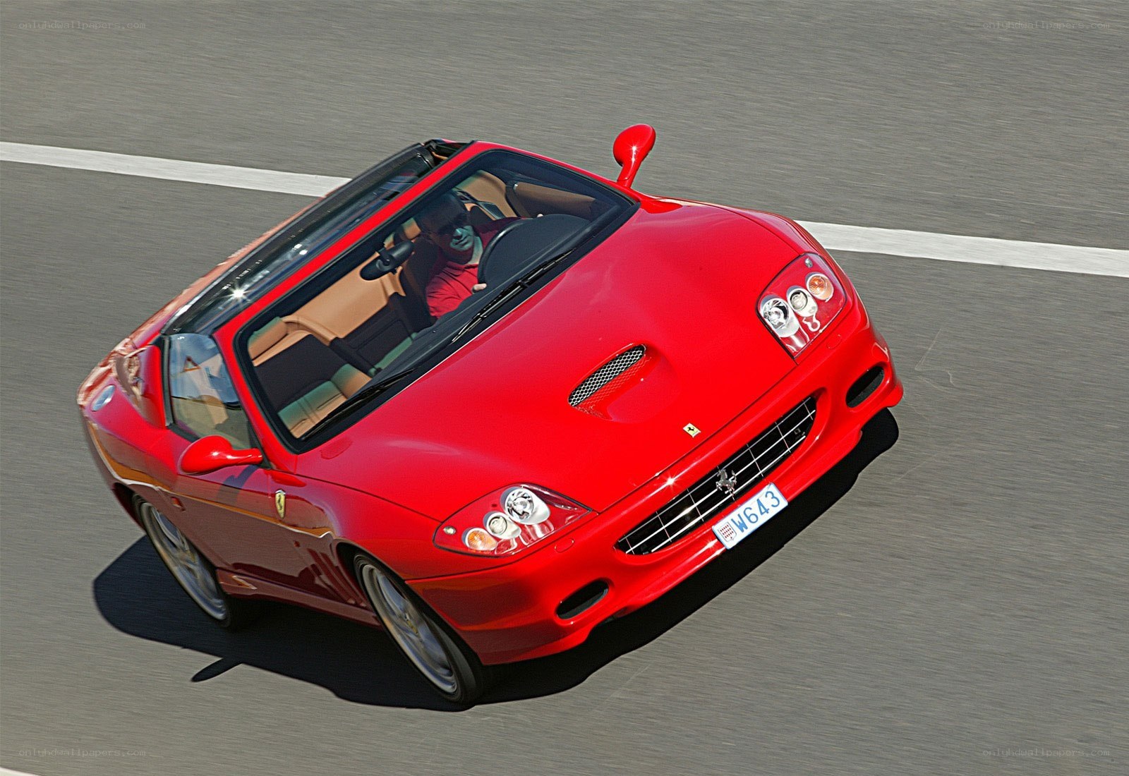 Red Ferrari convertible in motion