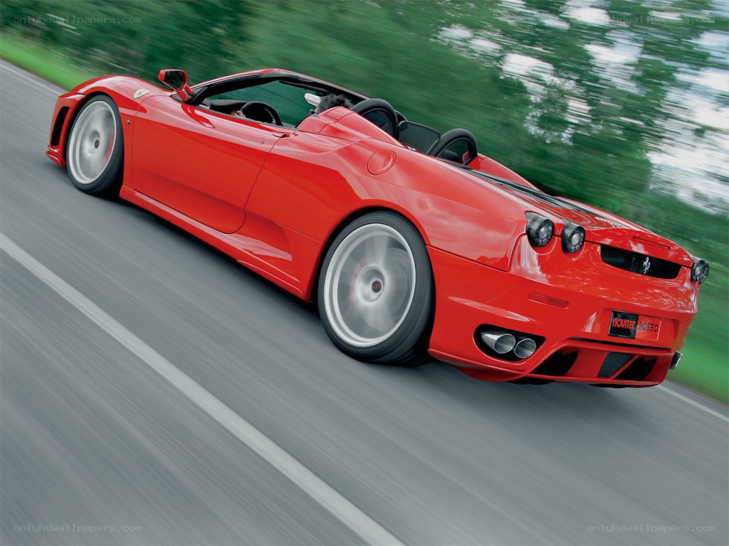 Red Ferrari convertible in motion