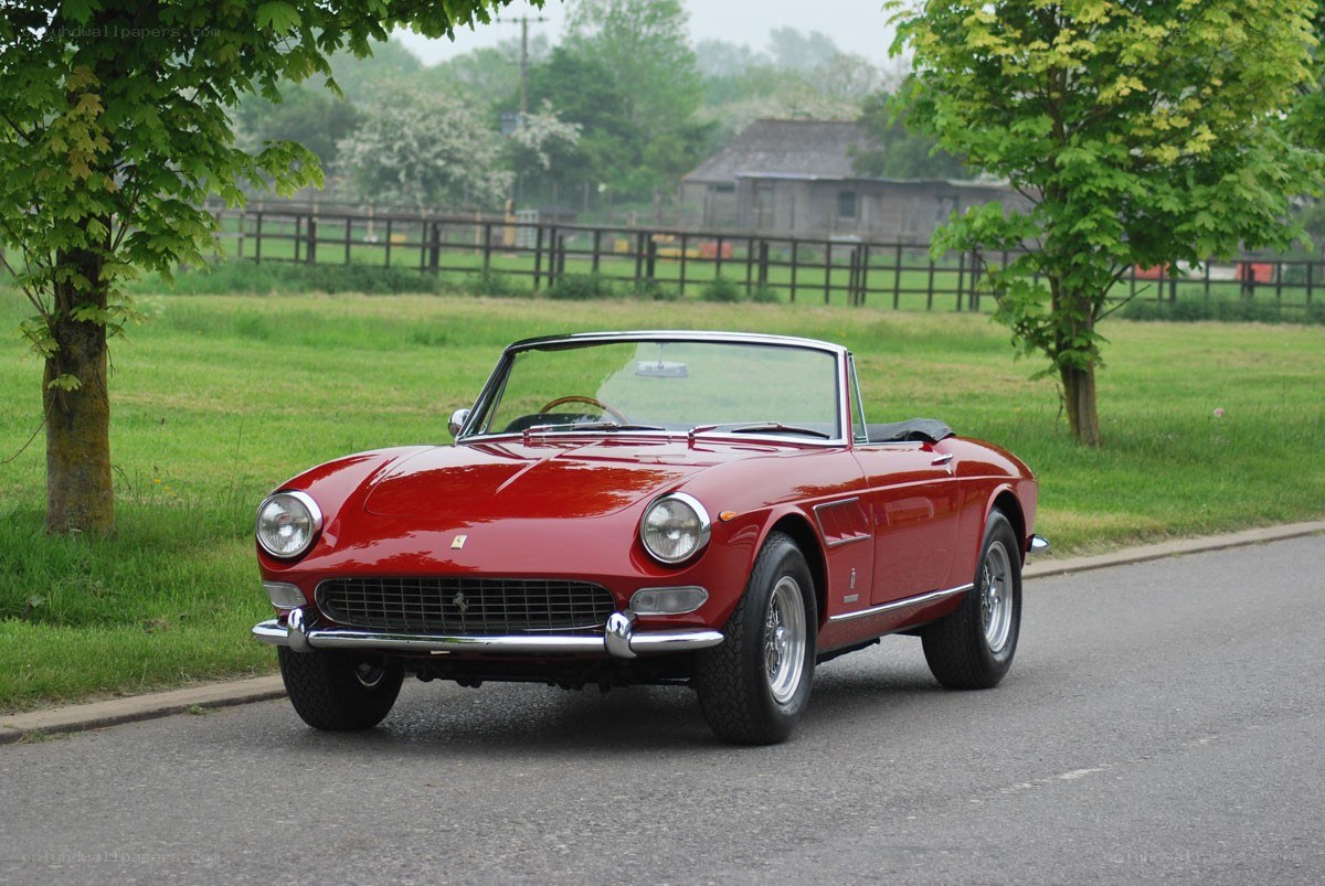 Red Ferrari convertible on road