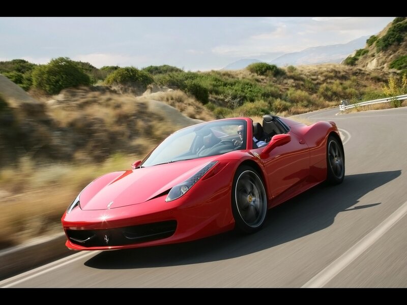 Red Ferrari convertible on winding road