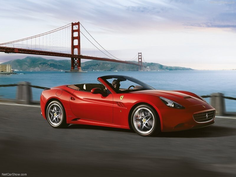 Red Ferrari driving by Golden Gate Bridge