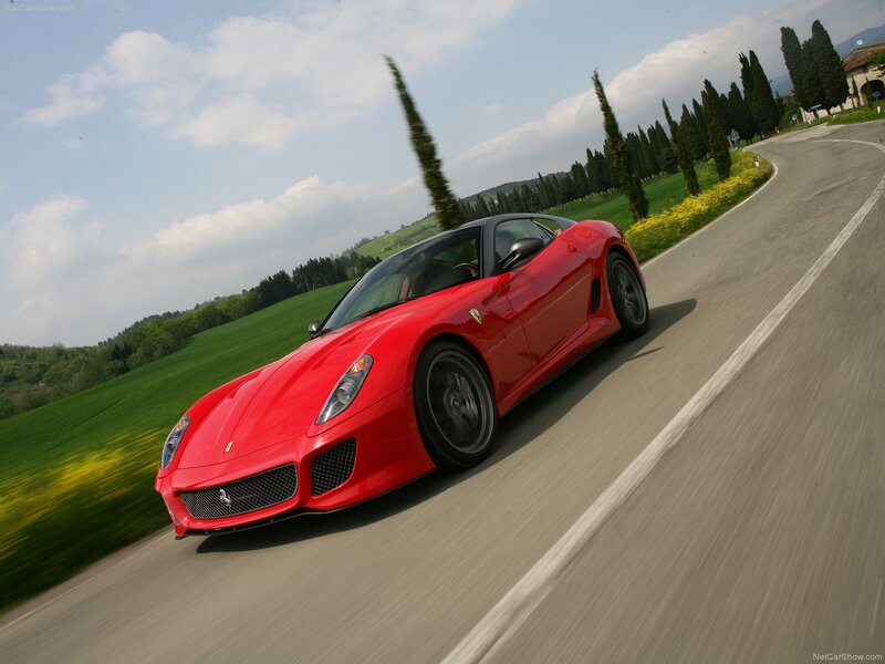Red Ferrari driving on a country road