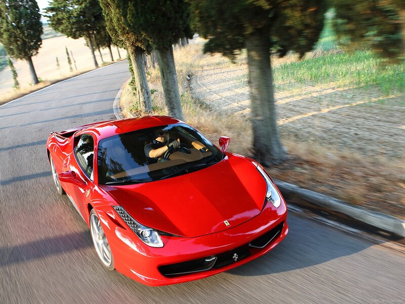 Red Ferrari driving on a country road