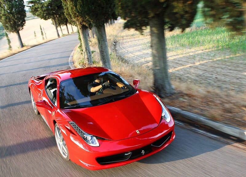 Red Ferrari driving on a country road
