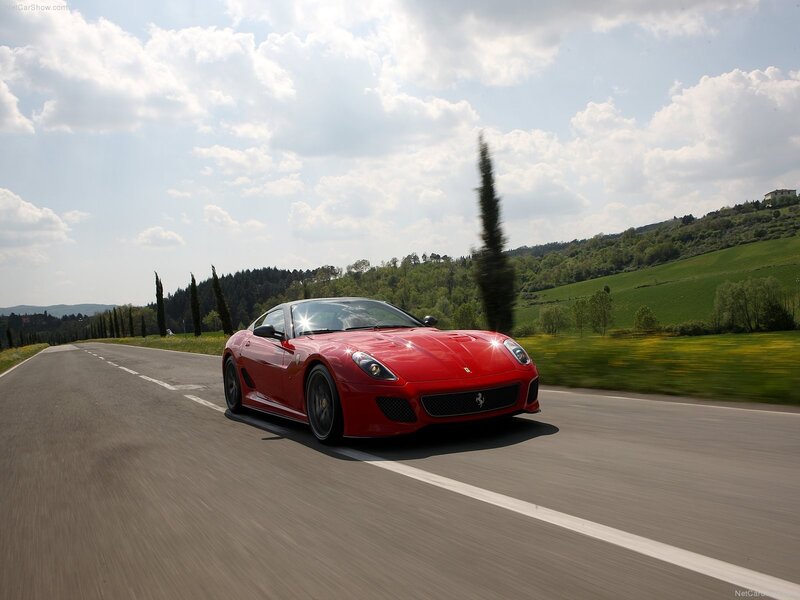 Red Ferrari driving on a country road