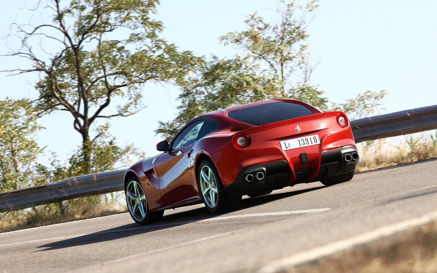 Red Ferrari driving on a road