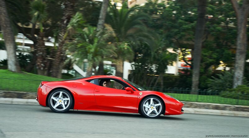 Red Ferrari driving on a road