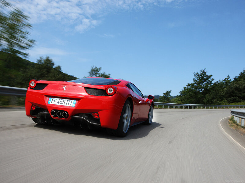 Red Ferrari driving on a road