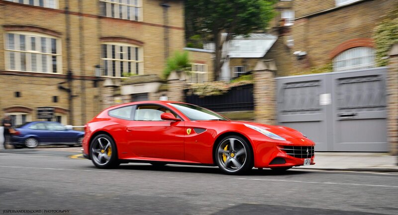 Red Ferrari driving on city street