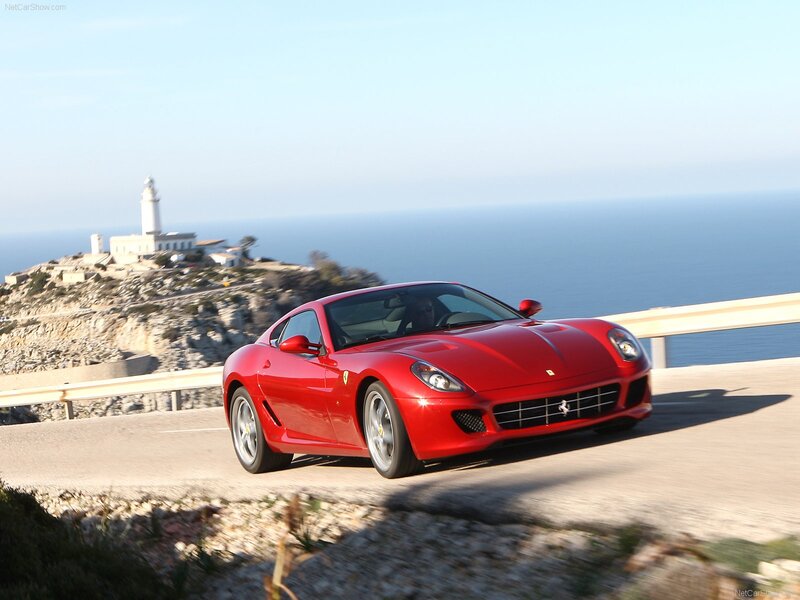 Red Ferrari driving on coastal road