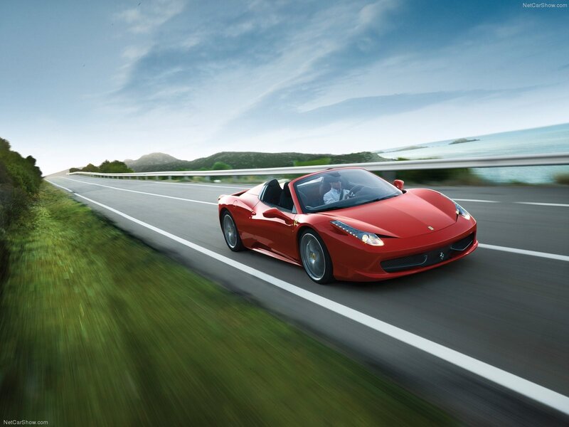 Red Ferrari driving on coastal road
