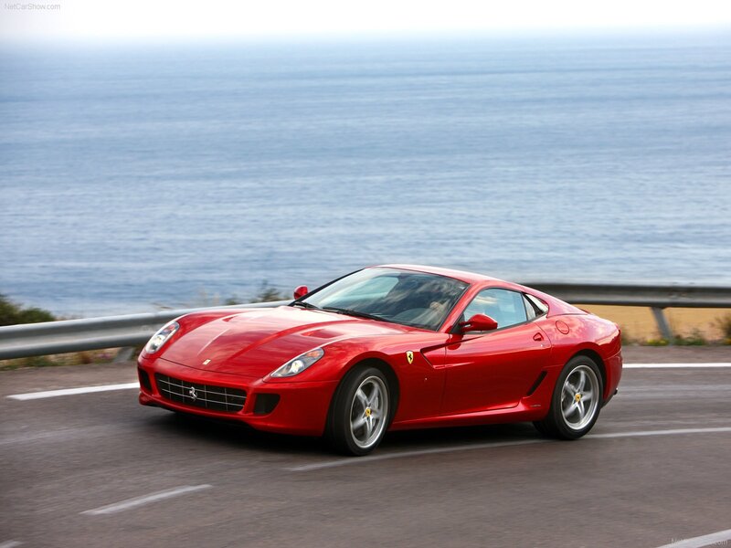 Red Ferrari driving on coastal road
