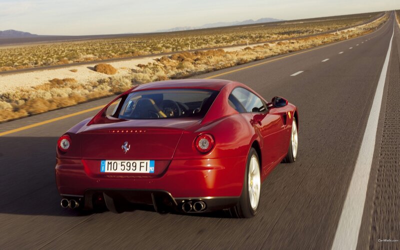 Red Ferrari driving on desert road